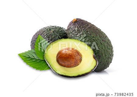 Avocado with cut in halfand green leaves isolated on white background. Avocado with cut in halfand green leaves isolated on white background. 73982435