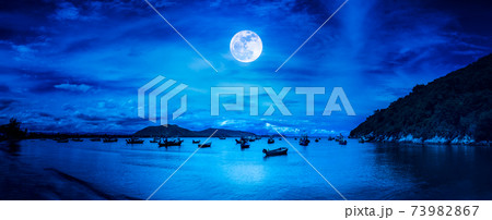 Beautiful panorama nature landscape. Beach by the sea with mountains and full moon at nighttime. Beautiful panorama nature landscape. Beach by the sea with mountains and full moon at nighttime. 73982867