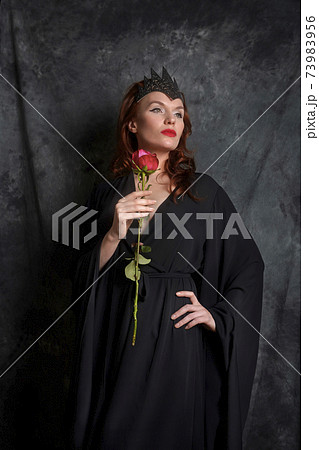 Woman in black dress with red rose Woman in black dress with red rose 73983956