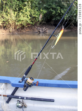 Fishing tackle fixed on the side of the boat during fishing. 73985328