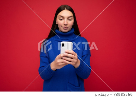 Beautiful young woman wearing casual clothes standing isolated over background surfing on the 73985566