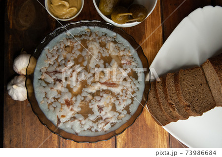 Jellied meat on a brown wooden background.Homemade jelly meat with mustard and horseradish on the table. Holodets 73986684