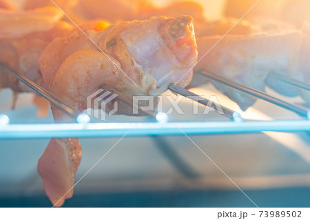 Roasting raw chicken wings on the rack inside oven 73989502