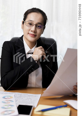 Business women smileing wear glasses holding document paper chart sitting at office. business people using computer PC  at office. Business at home concept. 73990448