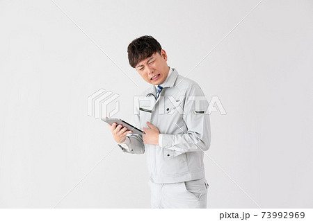 白バックの悩む若い作業員 白バックの悩む若い作業員 73992969