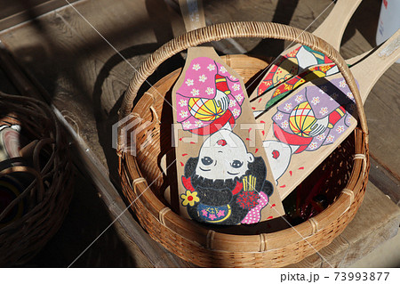 竹かごに入った昭和レトロな女の子の絵柄の羽子板 お正月の玩具の写真