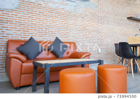 Leather orange sofa with brick wall brown background 73994500