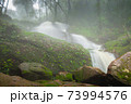 waterfall in forest in rain season 73994576