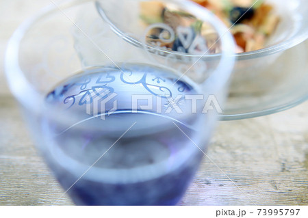 ガラスのコップにバタフライピーの青いハーブティーの写真素材