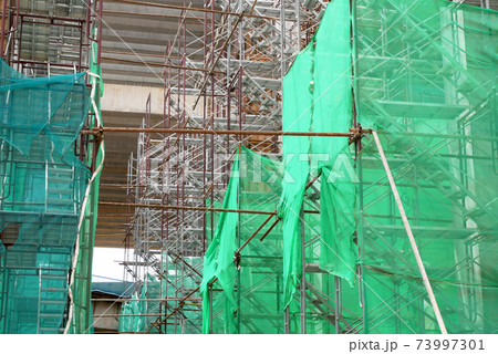 SHAH ALAM, MALAYSIA -AUGUST 8, 2020: Temporary staircase and falsework are used as the temporary support during construction. It is wrapped with safety netting for safety purposes. Installed by worker SHAH ALAM, MALAYSIA -AUGUST 8, 2020: Temporary staircase and falsework are used as the temporary support during construction. It is wrapped with safety netting for safety purposes. Installed by worker 73997301