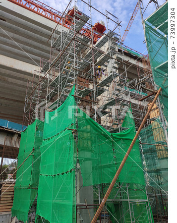 SHAH ALAM, MALAYSIA -AUGUST 8, 2020: Temporary staircase and falsework are used as the temporary support during construction. It is wrapped with safety netting for safety purposes. Installed by worker 73997304