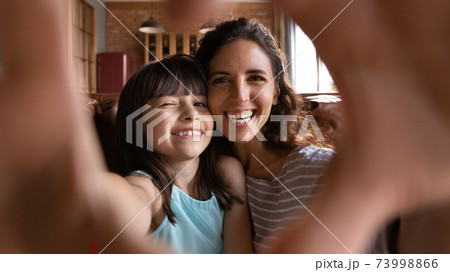 Head shot portrait happy mother and daughter taking selfie Head shot portrait happy mother and daughter taking selfie 73998866