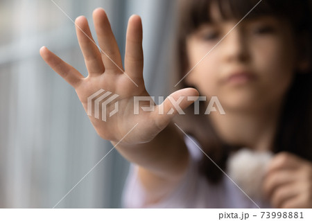 Close up lonely little girl offering hand, asking help 73998881