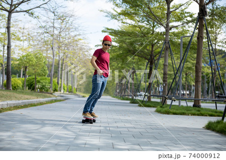 Asian woman skateboarder skateboarding in modern city Asian woman skateboarder skateboarding in modern city 74000912