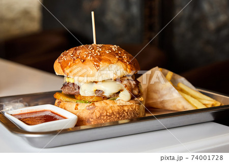 Fast food hamburger and french fries on a metal plate Fast food hamburger and french fries on a metal plate 74001728