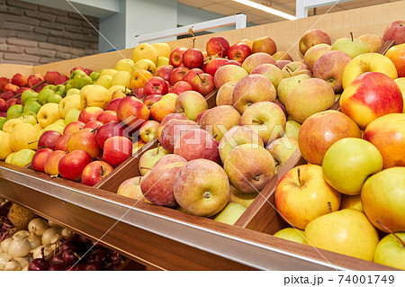 Multicolored apples in wooden boxes on store shelves Multicolored apples in wooden boxes on store shelves 74001749