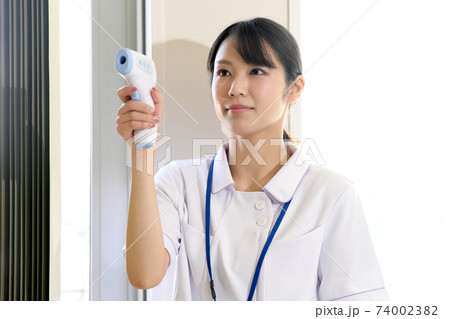 検温する若い女性の看護師 74002382