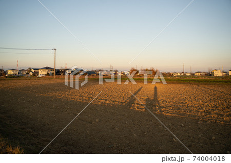 夕暮れの散歩道を歩く影 74004018