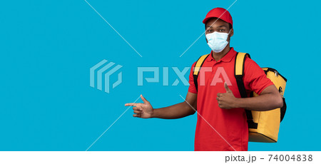 African american delivery man in mask pointing at copy space African american delivery man in mask pointing at copy space 74004838