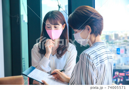 シェアオフィスでミーティングするマスクをした若いビジネスウーマン シェアオフィスでミーティングするマスクをした若いビジネスウーマン 74005571