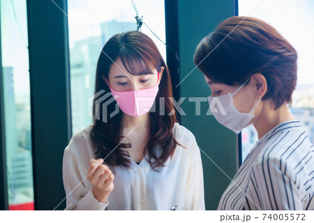 シェアオフィスでミーティングするマスクをした若いビジネスウーマン シェアオフィスでミーティングするマスクをした若いビジネスウーマン 74005572