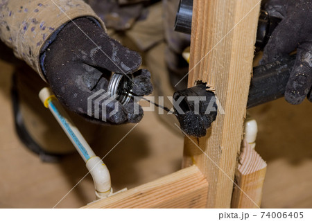 Plumber joining PVC sewage drain pipes on a home under construction Plumber joining PVC sewage drain pipes on a home under construction 74006405