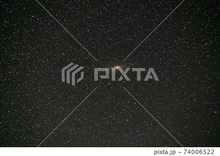 Black night stars covered sky with bright Andromeda galaxy in the middle. 74006522