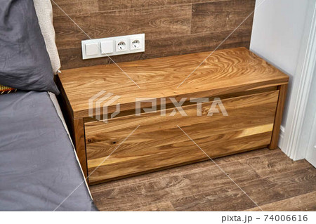 Solid wood nightstand in the interior. Solid elm nightstand. Details furniture Solid wood nightstand in the interior. Solid elm nightstand. Details furniture 74006616