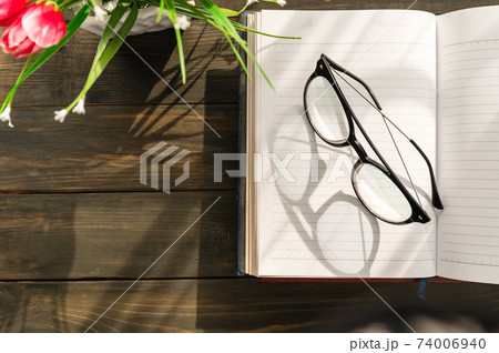 Reading glasses put on open book Reading glasses put on open book 74006940