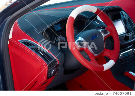 Car dashboard. Car interior details. Red and black alcantara with stitching Car dashboard. Car interior details. Red and black alcantara with stitching 74007091