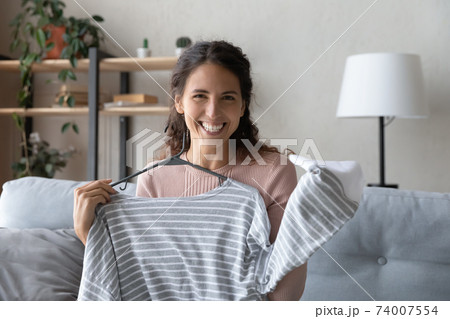 Gadget screen view happy young female influencer showing clothes. Gadget screen view happy young female influencer showing clothes. 74007554