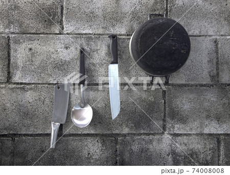 Kitchen equipment hangs on a wall of concrete blocks. Outdoor kitchen equipment, Thailand. Kitchen equipment hangs on a wall of concrete blocks. Outdoor kitchen equipment, Thailand. 74008008
