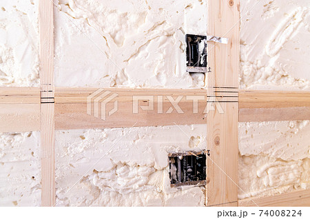 吹付け断熱を施した新築一戸建ての工事現場の壁とコンセント部分 74008224