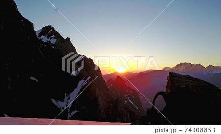 Epic red dawn on top of snowy mountains. Epic red dawn on top of snowy mountains. 74008853