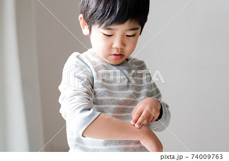 乾燥した肌に保湿クリームを塗る男の子 74009763