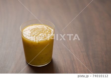 Mango lulo smoothie on walnut wood table with copy space Mango lulo smoothie on walnut wood table with copy space 74010112