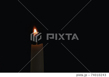 burning candle on black background burning candle on black background 74010243