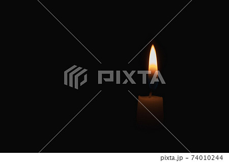 burning candle on black background 74010244