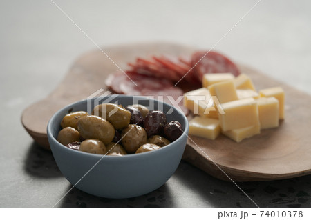 olives, salami and vintage cheese on concrete countertop olives, salami and vintage cheese on concrete countertop 74010378