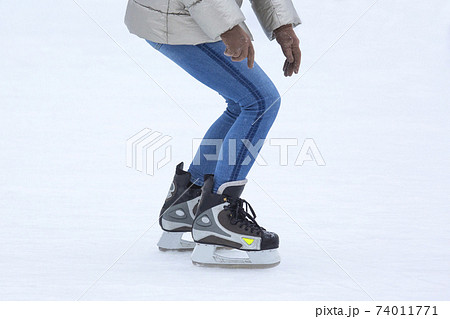 Legs of a man skating on an ice rink. Hobbies and sports. Vacations and winter activities. Legs of a man skating on an ice rink. Hobbies and sports. Vacations and winter activities. 74011771