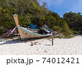 A broken boat stands on the sand. Boat by the sea. Fishing boat washed ashore 74012421