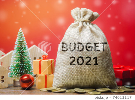 Money bag Budget 2021, Christmas tree, houses and gifts. Accumulating money and planning a budget. Business and finance. Loan, deposit, credit. Promotions, investments. New Year, Xmas winter holiday Money bag Budget 2021, Christmas tree, houses and gifts. Accumulating money and planning a budget. Business and finance. Loan, deposit, credit. Promotions, investments. New Year, Xmas winter holiday 74013117