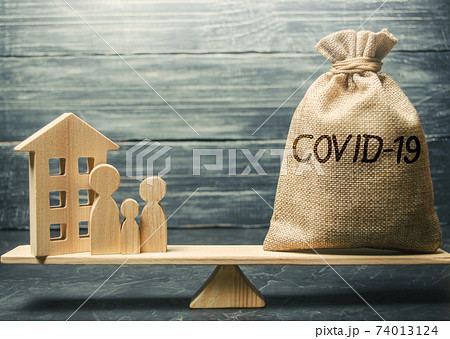 A family with a Covid-19 bag on the scales. State support for infected and sick people. Financial help, fund. Coronavirus pandemic infection. Healthcare, medicine. Money for infected people. 74013124