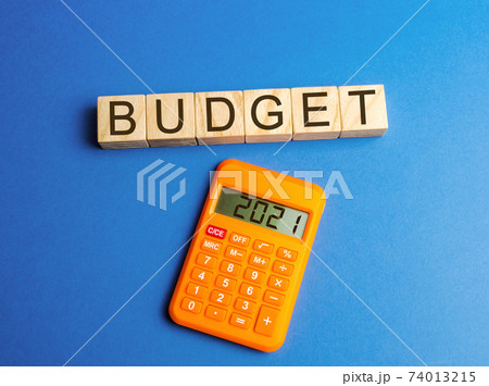 Wooden blocks with the word budget and calculator 2021. Accumulating money and planning a budget. Business and finance. Loan, deposit, credit. Investments. Goals, income 74013215