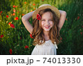 cute little girl in meadow with red poppies 74013330