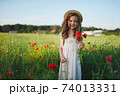 cute little girl in meadow with red poppies 74013331