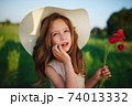 cute little girl in meadow with red poppies 74013332