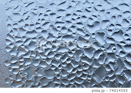 Textured pattern of condensation on the glass of the window frame. 74014503