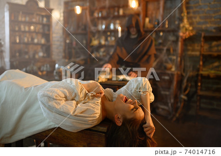 Exorcist casting out demons from crazy woman Exorcist casting out demons from crazy woman 74014716