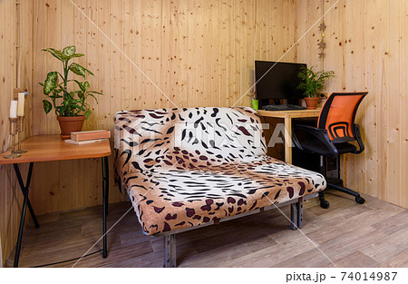 Interior of a country house room, next to the sofa there is a computer table, on the other side there is a coffee table 74014987